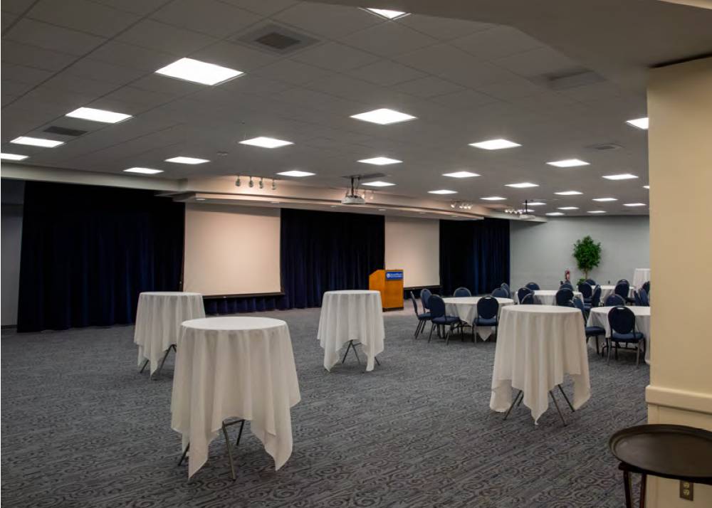 A view of the Grand River Room with standing tables and seated tables.